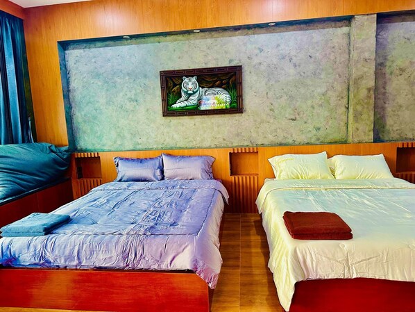 A hotel room with two beds, a large painting of a tiger, wooden headboards, and a tiled floor. - Sky country resort at khanom (Khanom)