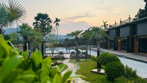 Un resort con piscina, palmeras y un camino que lleva a un edificio.