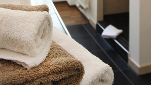 Een badkamer met een witte badkuip, een handdoek en een douche.