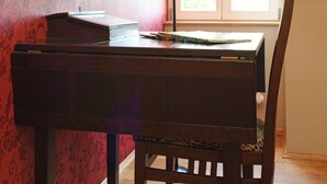 Een kamer met een houten bureau, een stoel, een lamp en een raam met jaloezieën.