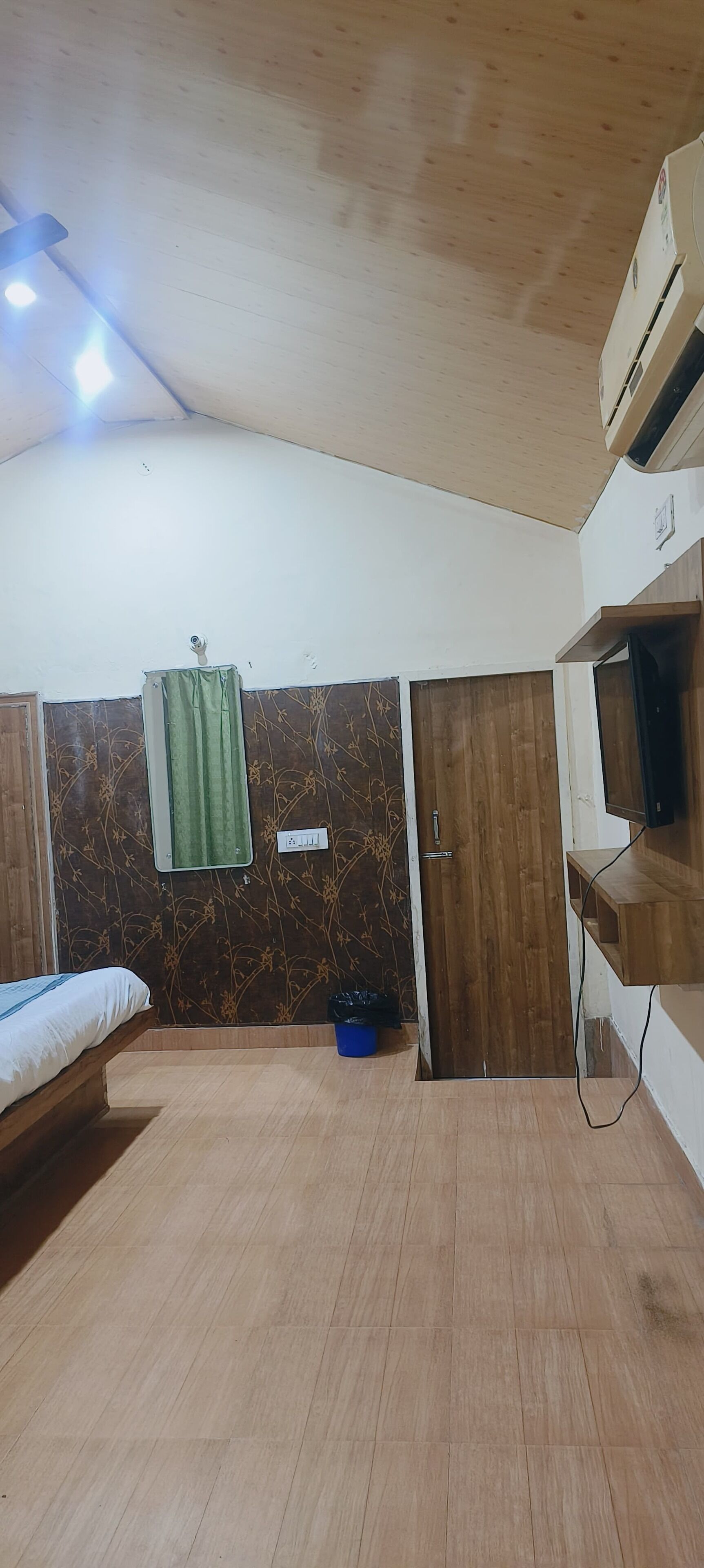 Une chambre équipée d’un lit, d’un appareil de climatisation, d’une télévision et d’une armoire.