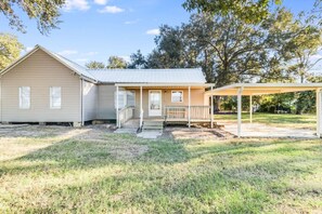 A single-story house with a covered porch and a small deck.