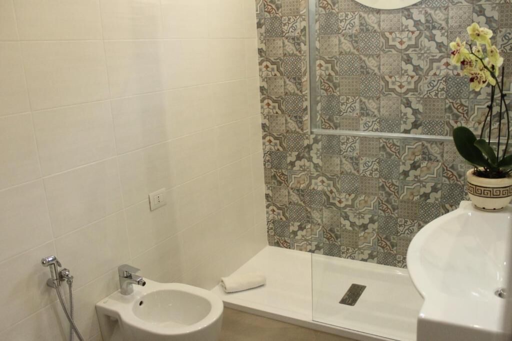 Un baño con bidé, lavabo y espejo.