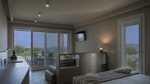 A modern bedroom with a large bed, a built-in desk, and a balcony with a view. - AlMar Apartments by Alma di Alghero (Alghero)