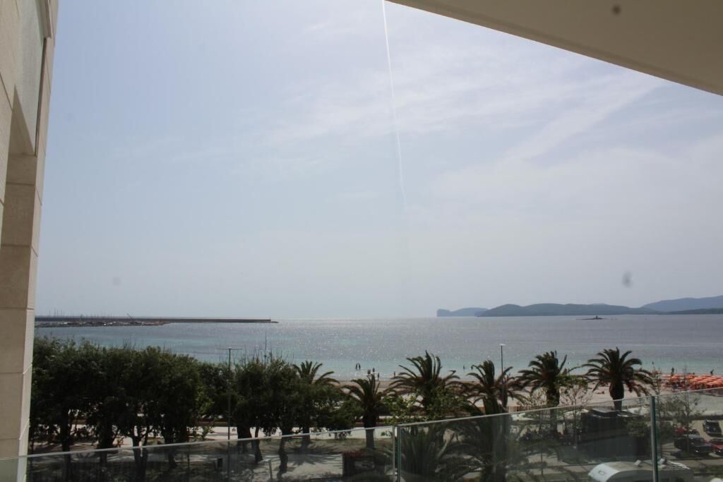 Een balkon met uitzicht op een strand en de zee.