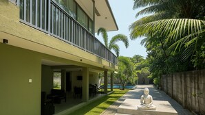 A modern building with a covered patio area, outdoor seating, and a statue. - Moi Dambulla by DBI (Sigiriya)