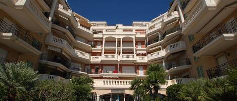 A multi-story hotel with a central courtyard, balconies, and a sign reading "VICTORIA BEACH".