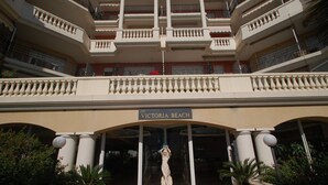 Un edificio de varios pisos con un letrero que dice 'VICTORIA BEACH'.