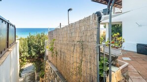 A coastal property with a bamboo fence, a stone pathway, and a balcony overlooking the sea. - Casa Ines Costa Rei, Sea View, 3 min from the Beach. (Costa Rei)