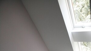 Ein modernes Badezimmer mit einer freistehenden Badewanne, einer Duschbrause und einem Fenster für natürliches Licht.