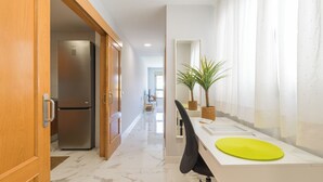 A modern kitchen with a stainless steel refrigerator, wooden cabinets, and a marble floor. - CITY FAMILY AUDITORIUM (Las Palmas de Gran Canaria)