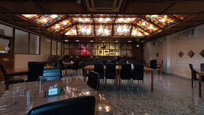 A conference room with a large table, chairs, and a stained glass ceiling. - Hotel Mainak & Health Club (Port Blair)