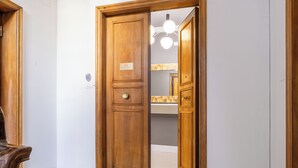 Puerta de madera con un cartel que indica la habitación número 17, que da a un baño con un perchero y un espejo.