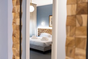 A hotel room with a bed, a nightstand, a wall clock, and a framed picture on the wall. - Pier Capponi 17 Room & Suites (Florence)