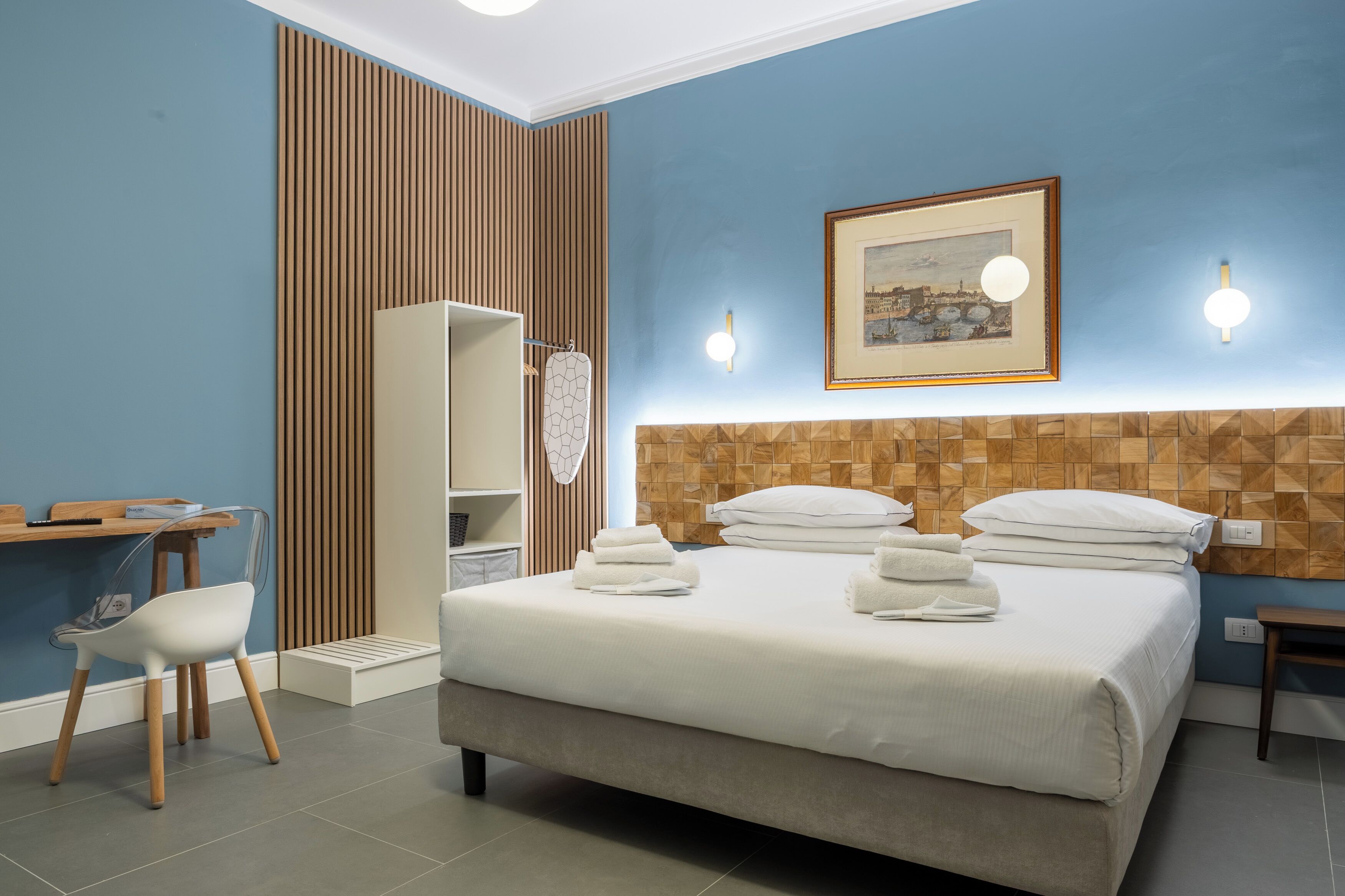 Ein Schlafzimmer mit einem Bett, einem Schreibtisch, einem Stuhl und einem Kleiderschrank.