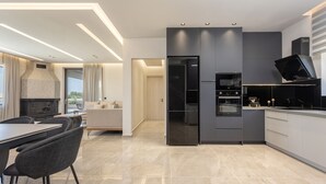Eine moderne Küche mit glatten Schränken, einem eingebauten Ofen und einem schwarzen Kühlschrank.