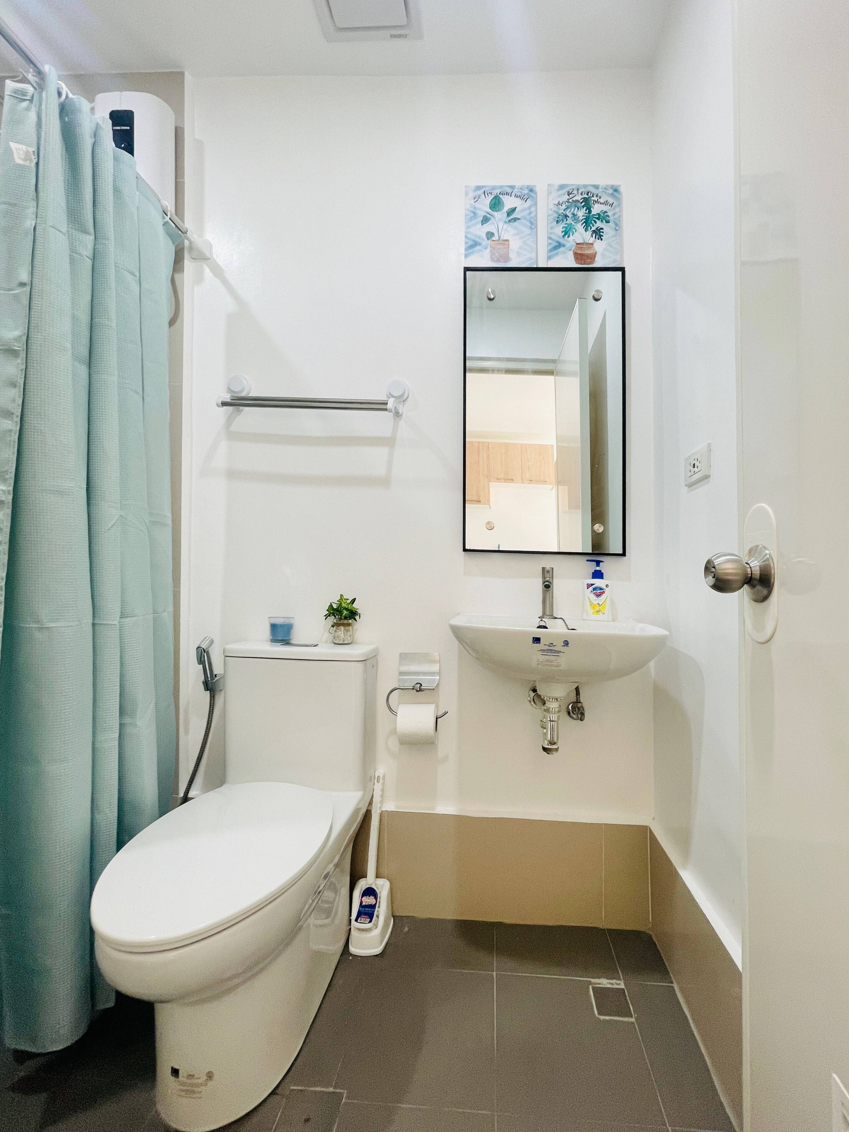 A small, clean bathroom with a toilet, sink, and shower curtain.