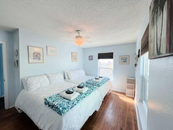 A bedroom with a bed, a ceiling fan, and a window.