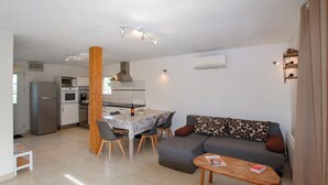 A modern apartment with a dining area, kitchen, and living space.