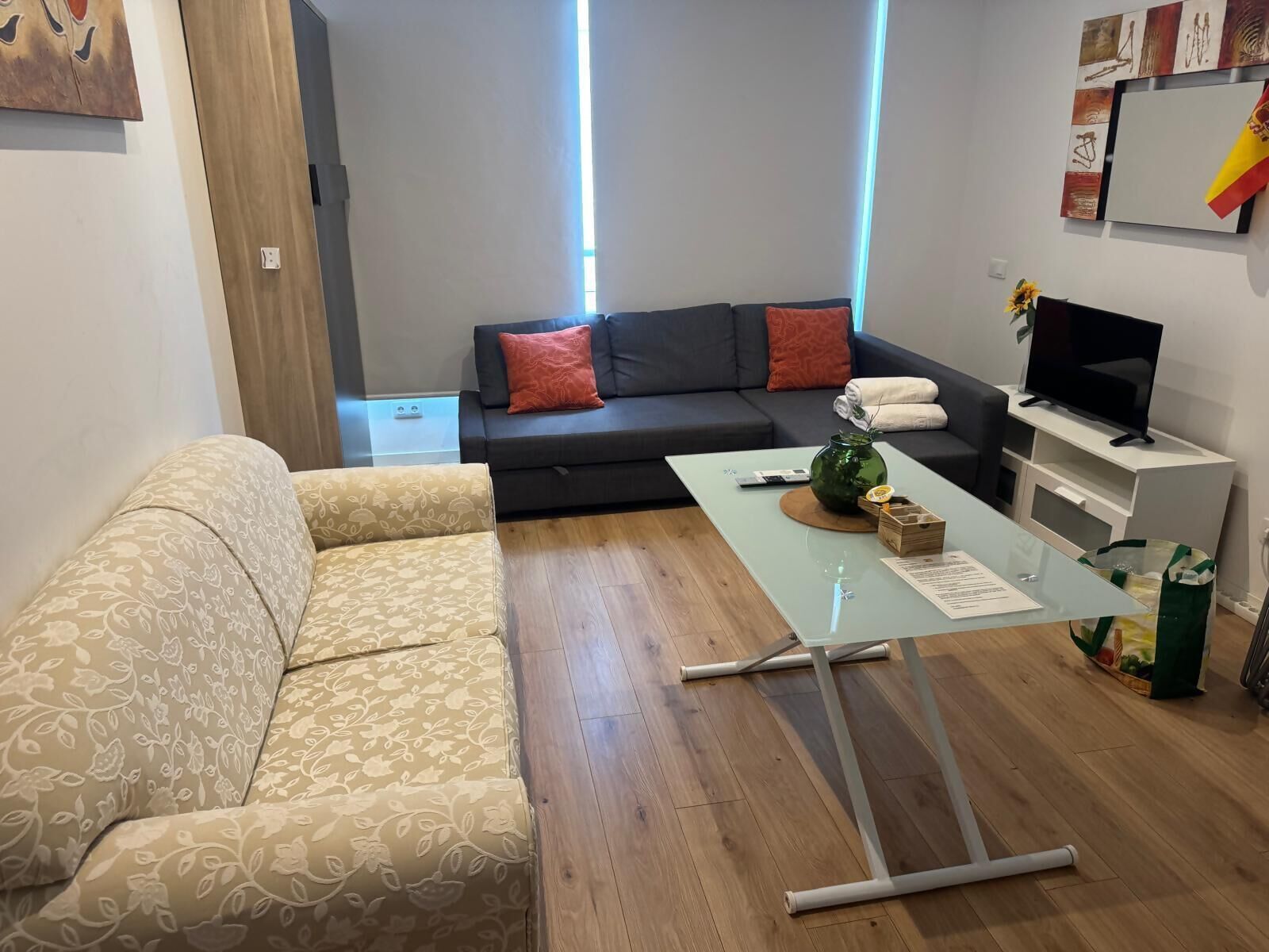 Un salon comprenant un canapé, une table basse, un téléviseur et une œuvre d’art accrochée au mur.