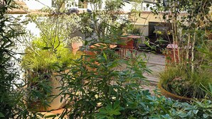 A courtyard with a stone tower, wooden buildings, and potted plants. - FÓLKLORE BOUTIQUE HOTEL (Sancerre)