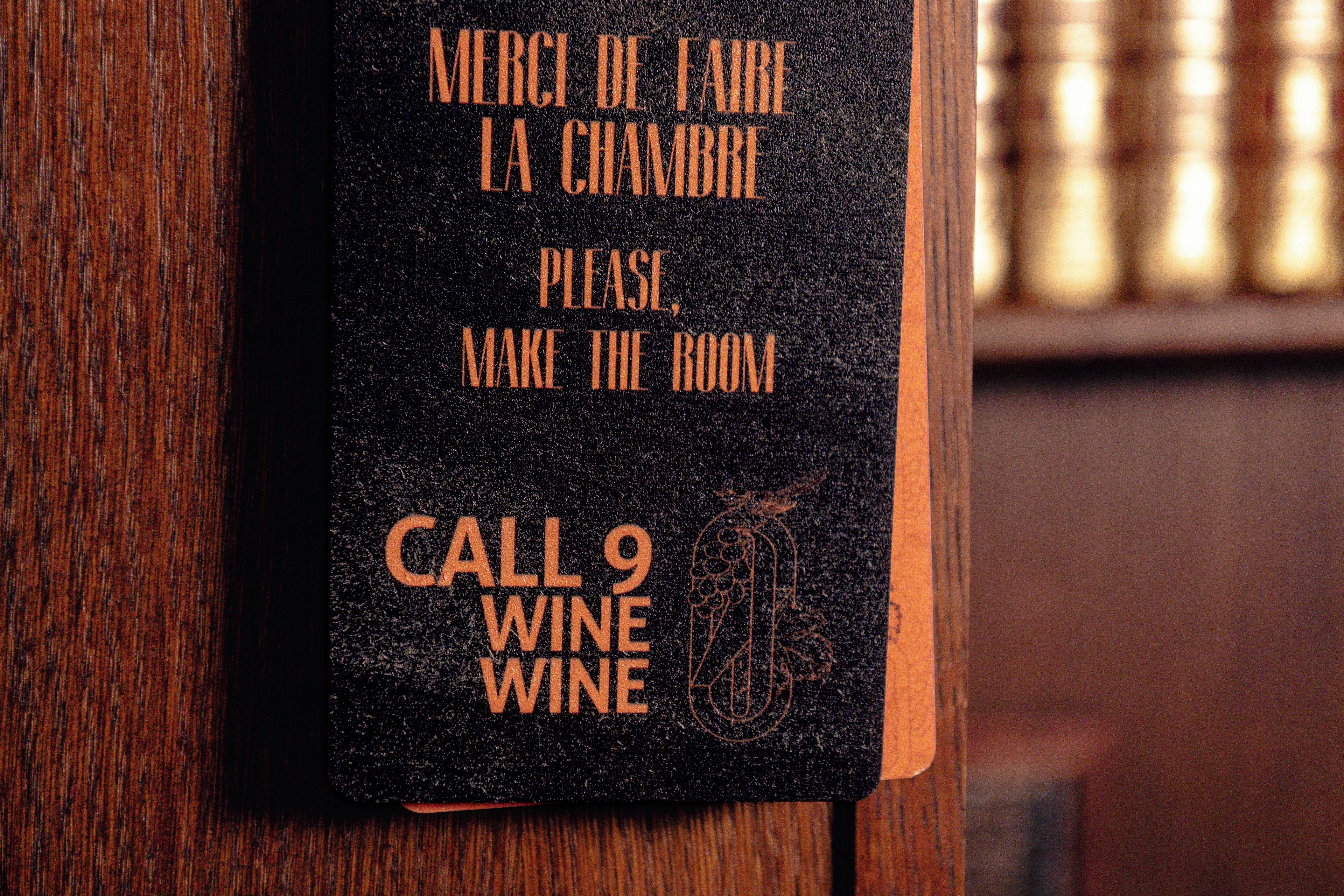 Un panneau noir avec du texte en français et une icône représentant un verre à vin, indiquant une invitation à profiter d’un service de dégustation de vin.