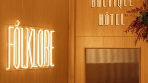 A wooden wall with illuminated signs reading "FOLKLORE" and "BOUTIQUE HOTEL". - FÓLKLORE BOUTIQUE HOTEL (Sancerre)