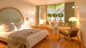 A modern bedroom with a large bed, a round headboard, a small seating area with a sofa and chairs, and a view of greenery through large windows. - FÓLKLORE BOUTIQUE HOTEL (Sancerre)