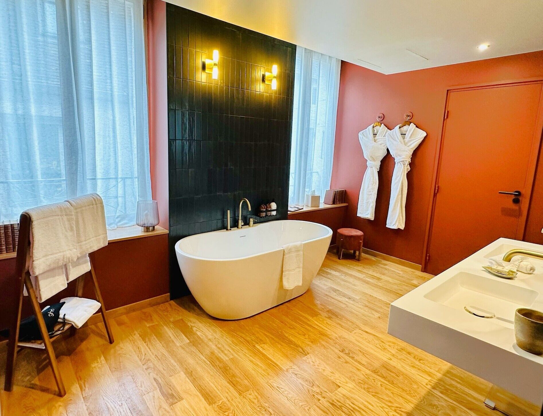 A modern bathroom with a freestanding bathtub, a separate sink area, and a vanity.