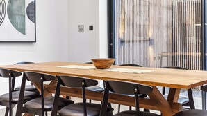 A wooden table with black chairs, a bowl, and a framed artwork on the wall. - Luxury Abode: 5-Bed Haven Ideal for Big Groups! (London)