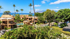 A resort with multiple buildings, a swimming pool, and a view of the ocean. - In the Center of It all, walkable Kihei comfort (Kihei)