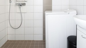 A compact bathroom with a shower, toilet, and sink.