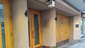 A row of wooden doors with a number sign above, indicating a hotel entrance.