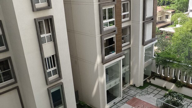 Un moderno edificio residenziale con una piscina rettangolare nel cortile interno.