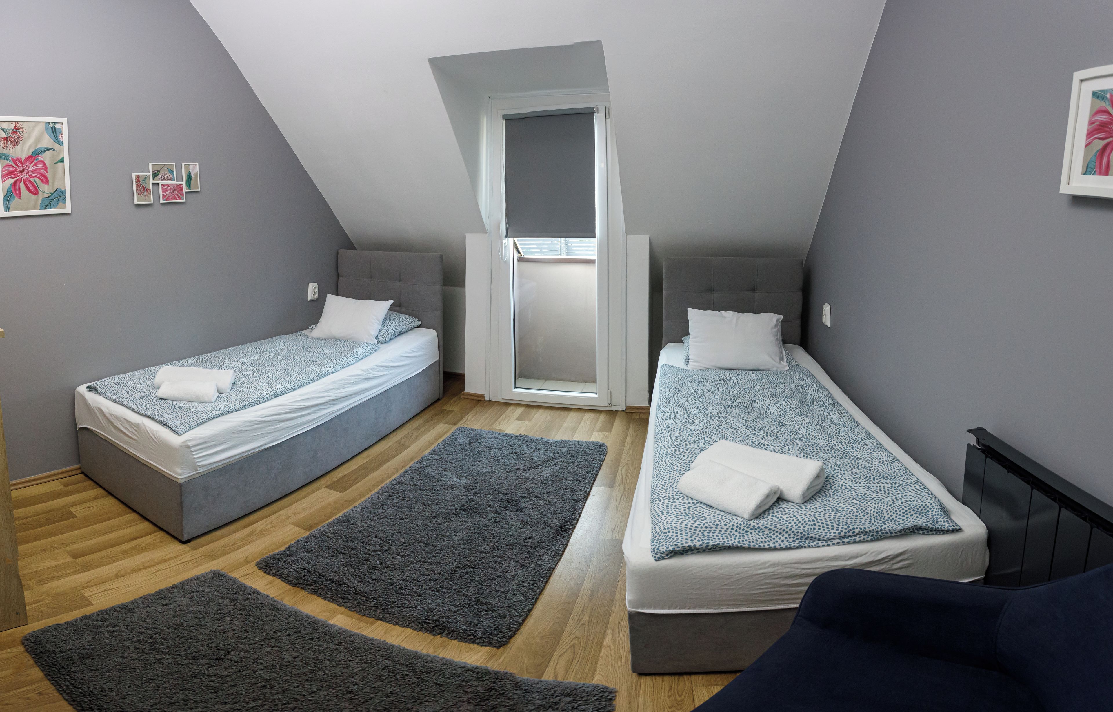 A bedroom with two single beds, a skylight, and a view of the sky.