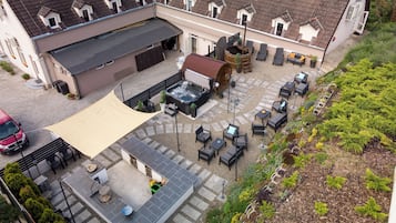 An aerial view of a courtyard with outdoor seating, a hot tub, and a garden area.