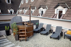 A rooftop terrace with a hot tub, lounge chairs, and potted plants. - Árnyas Panzió Gödöllő (Gödöllő)