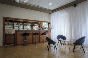 A bar area with a counter, stools, and a view of the outside through large windows. - Árnyas Panzió Gödöllő (Gödöllő)