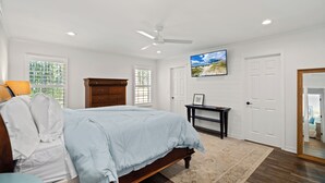 Une chambre à coucher avec un lit, une commode et un téléviseur fixé au mur.
