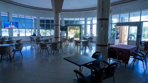 Un espacio interior amplio con techos altos, ventanas grandes y varias opciones de estar.