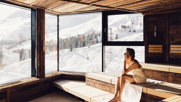A wooden cabin with large windows overlooking a snowy mountain landscape. - Hotel Schöne Aussicht (Soelden)