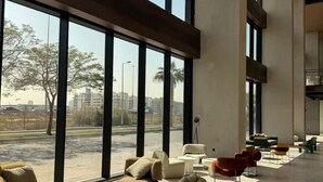 Amplio espacio interior con ventanas grandes, disposición moderna de asientos y vistas al exterior.