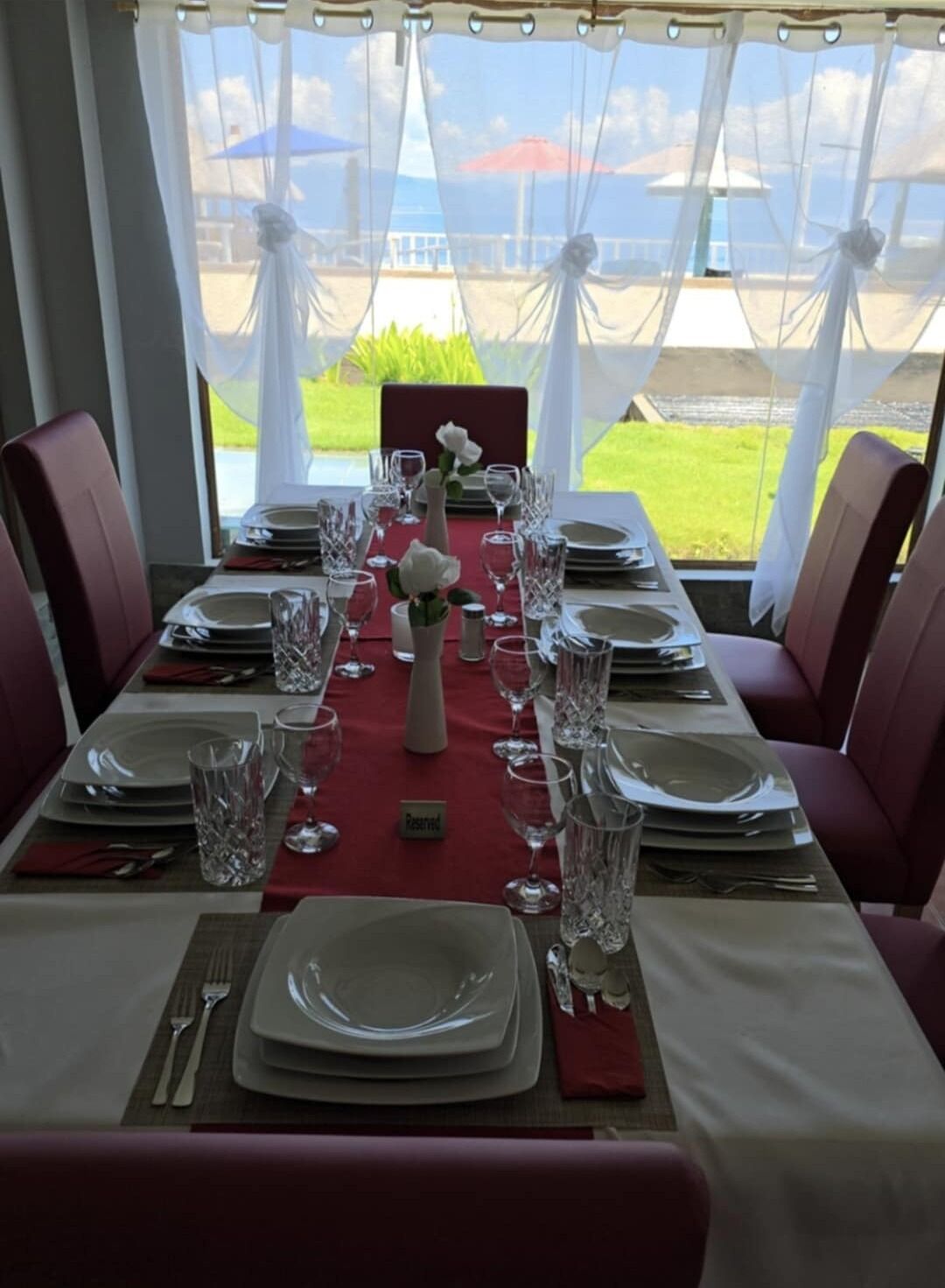 Mesa de comedor lista para una comida con vista al mar.