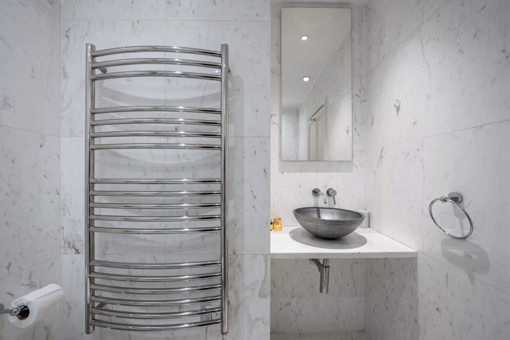 A bathroom with a glass shower enclosure, a sink with a bowl, and a mirror above the sink.