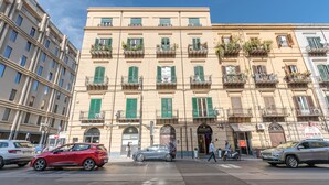 Un immeuble à plusieurs étages doté de balcons, d’une devanture de magasin et d’un passage piéton.
