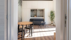 Un intérieur moderne comprenant un coin repas, un canapé et un grand tableau abstrait accroché au mur.