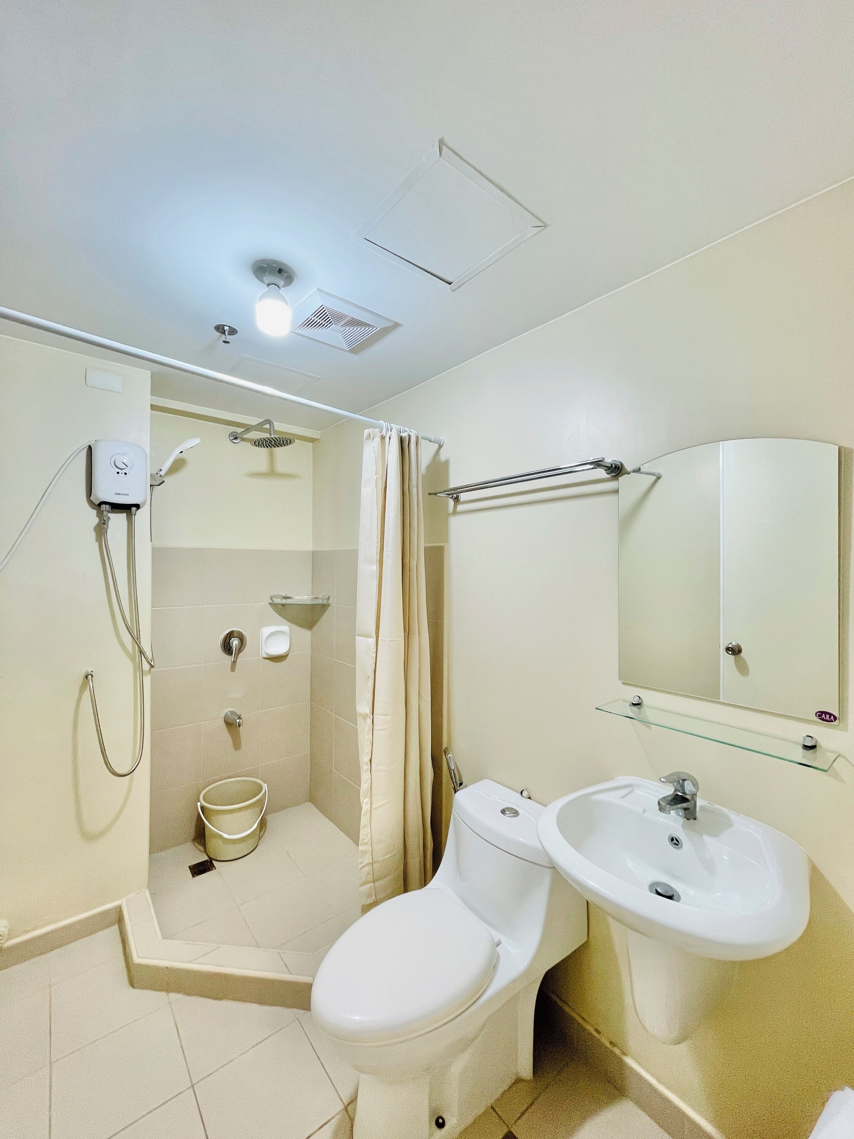 A bathroom with a toilet, bidet, and shower.