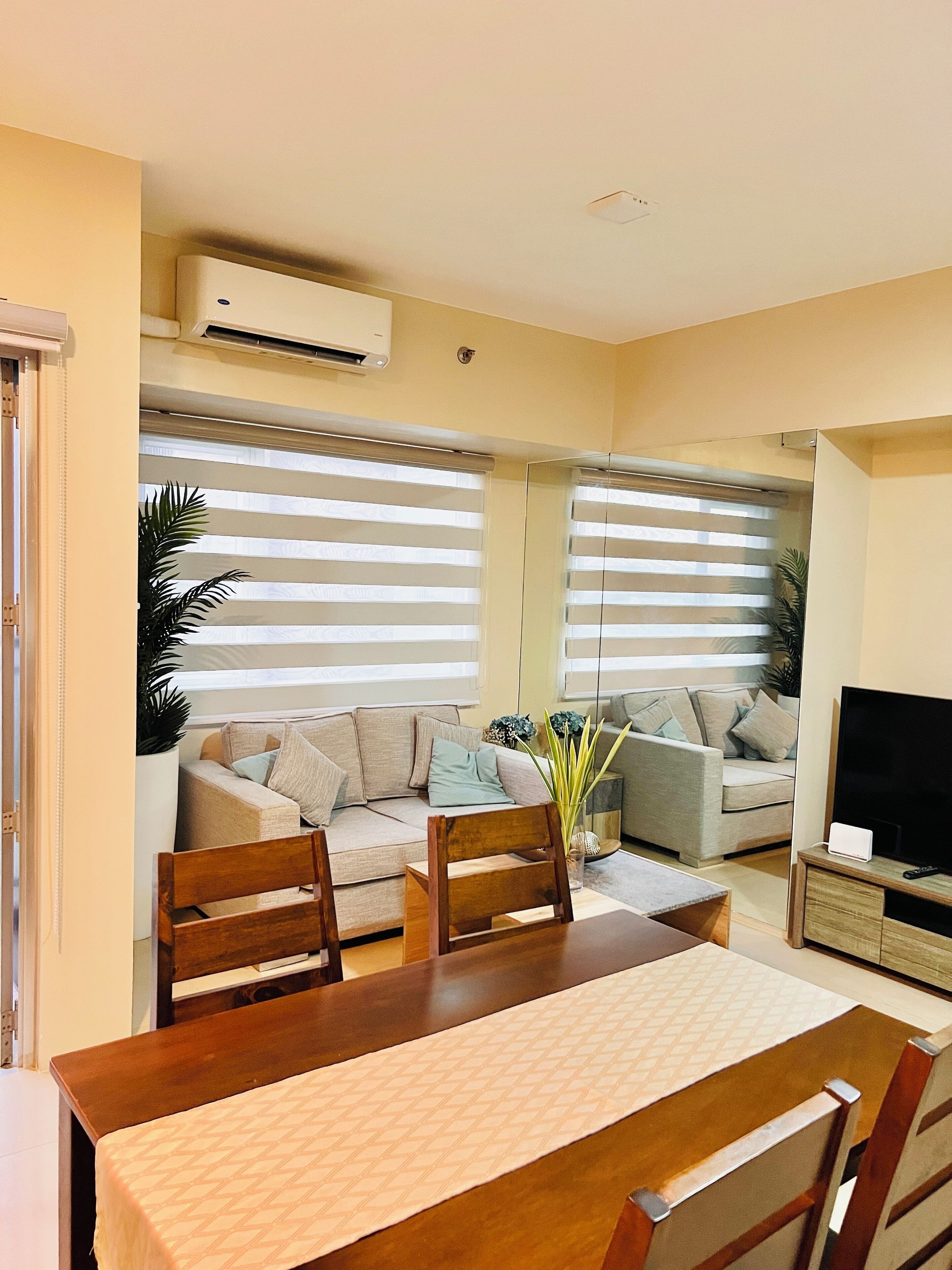 Una sala de estar con dos sofás, una mesa de centro y un mueble para televisión.