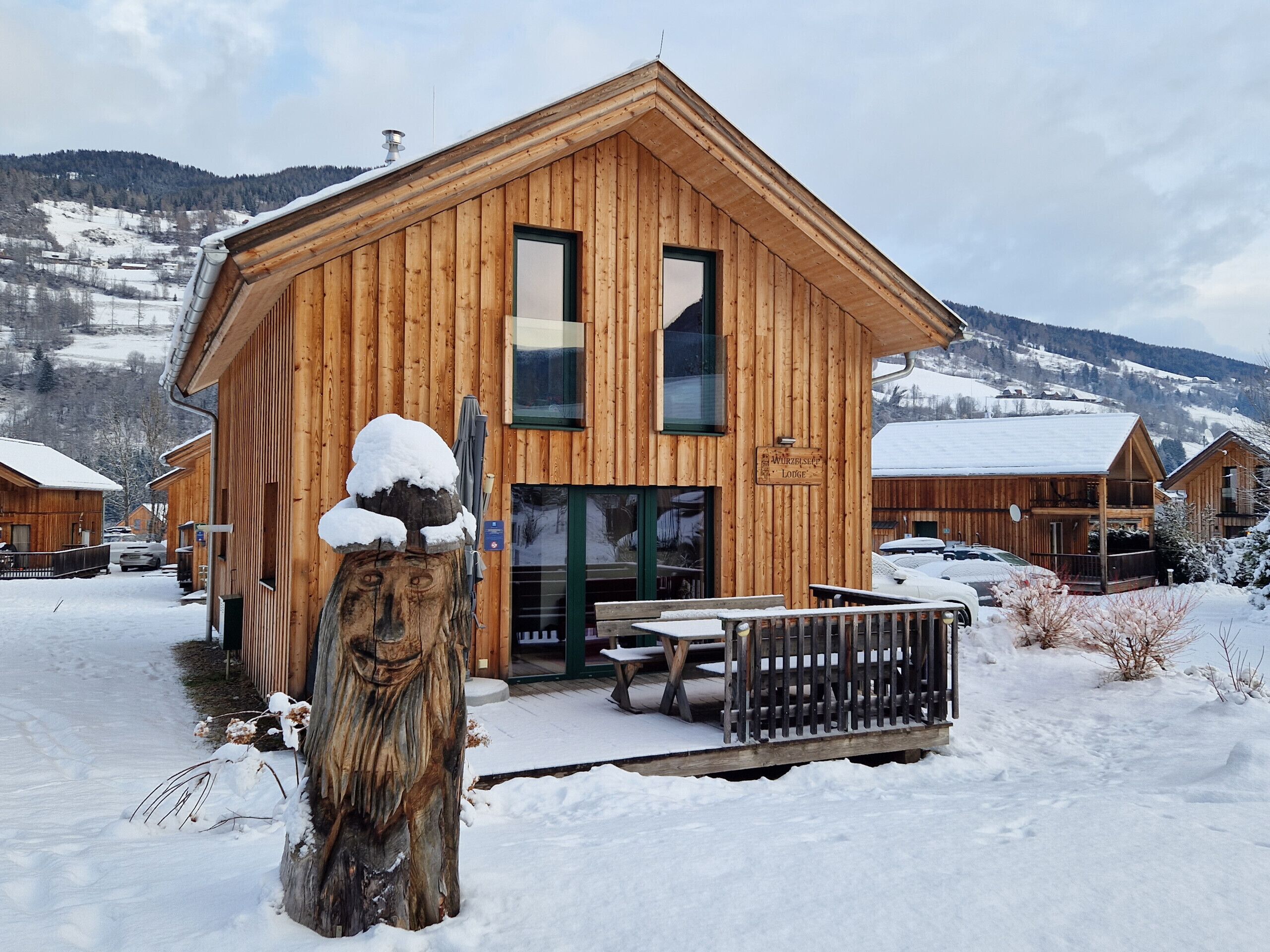 Un chalet en bois doté d’une grande entrée et d’une enseigne indiquant qu’il s’agit du « Wurzbacht Lodge ».