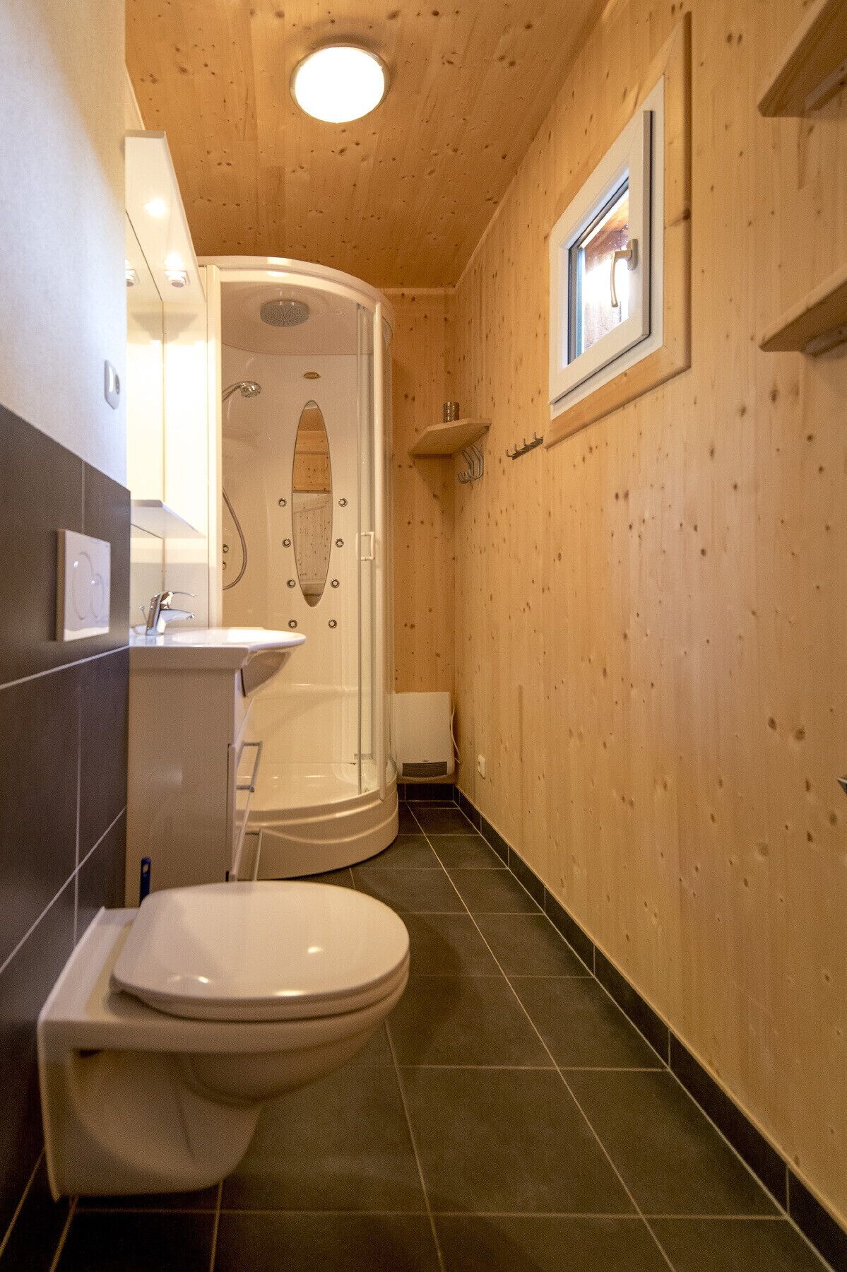 A compact bathroom with a shower, toilet, and sink.